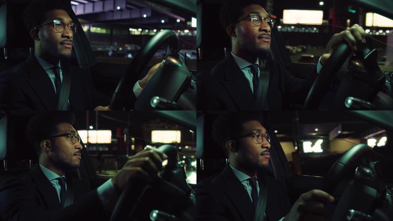 一个穿着西装的英俊黑人的肖像在晚上驾驶一辆豪华汽车，专注于道路。成功的非洲裔美国商人跟随交通信号安全