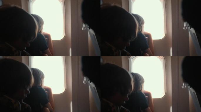 快乐的少女乘客在起飞去度假的航班上从黑暗的飞机窗户座位上看出来。