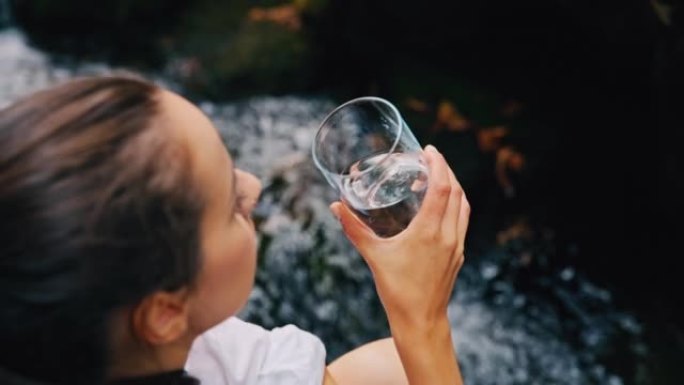 SLO MO女人从溪流中喝水