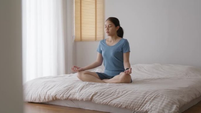亚洲人早起健康的生活平衡床上瑜伽姿势的好处。