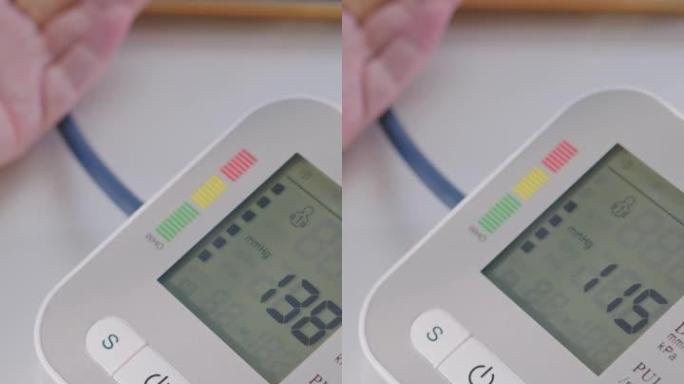 垂直射击高级妇女手使用医疗器械检查血压计和心率在家里。