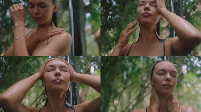 迷人的女人在淋浴穿着比基尼洗身体清洁皮肤与清爽的水享受自然美容温泉在大自然的户外淋浴