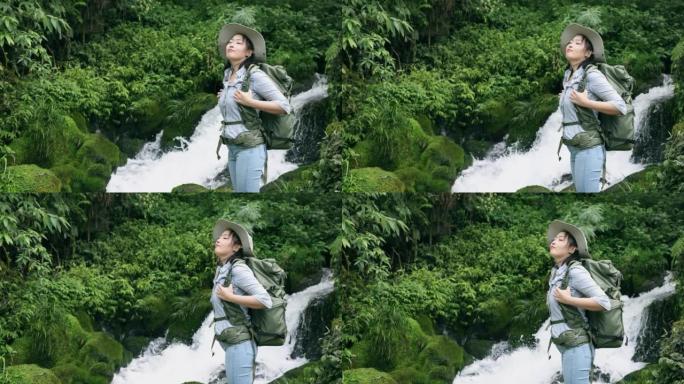 女徒步旅行者在山间小瀑布中放松