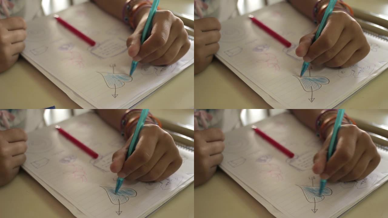 恋爱中的女学生在课堂上在笔记本上画一颗带有箭头形状的心。特写。