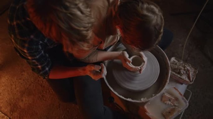SLO MO深情的年轻夫妇在陶艺工作室中塑粘土