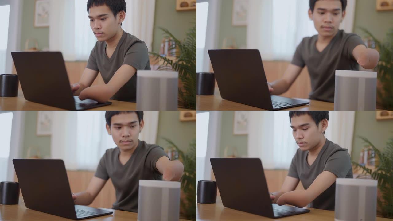 一个年轻人用笔记本电脑和咖啡在室内工作，家庭办公室的概念。