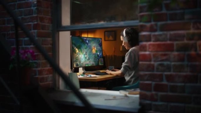 兴奋的女性玩家在个人电脑上玩在线视频游戏。女人享受RPG MOBA模拟视频游戏与有趣的特殊效果。在线