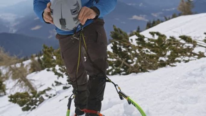 攀登雪山时戴着运动头盔的冰斧登山者