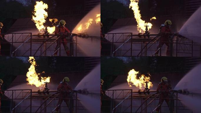 4k UHD消防员使用水雾式灭火器与石油钻机和天然气站的石油管道泄漏和爆炸引起的火焰进行战斗。消防员