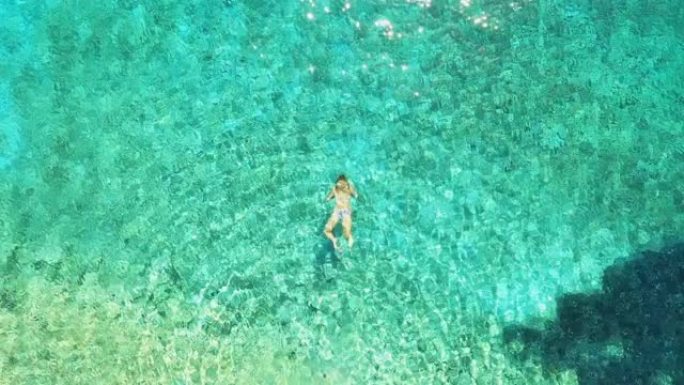 空中女子在亚得里亚海的绿松石水中游泳