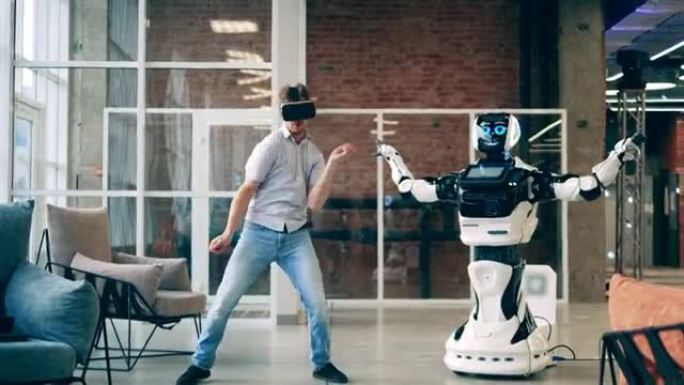 人与机器人交流概念。商人在半机械人旁边跳舞时戴着VR眼镜