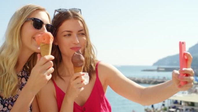 在意大利海岸的一个夏日里，两名年轻女子吃冰淇淋和自拍的4k视频片段