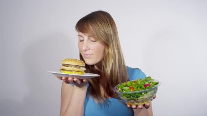肖像: 女人在权衡午餐选择时选择沙拉而不是汉堡。