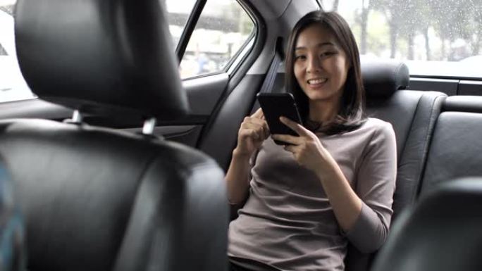亚洲女性在汽车上使用智能手机
