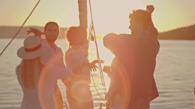 SLO MO一群年轻人在日落时在船上跳舞