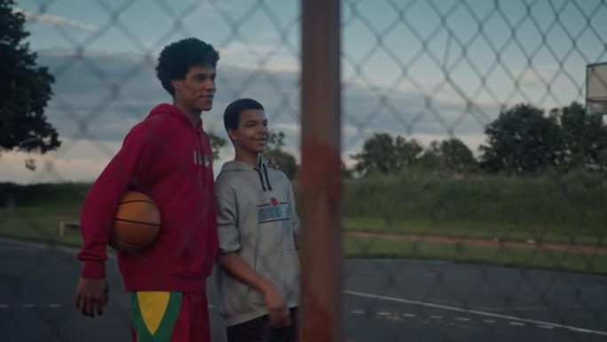 SLO MO两个十几岁的兄弟在打篮球时互相拥抱