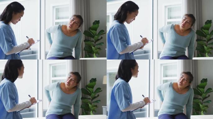 亚洲女性理疗师在咨询女性患者时做笔记