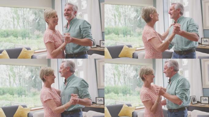 浪漫的高级退休夫妇一起在家里的休息室跳舞