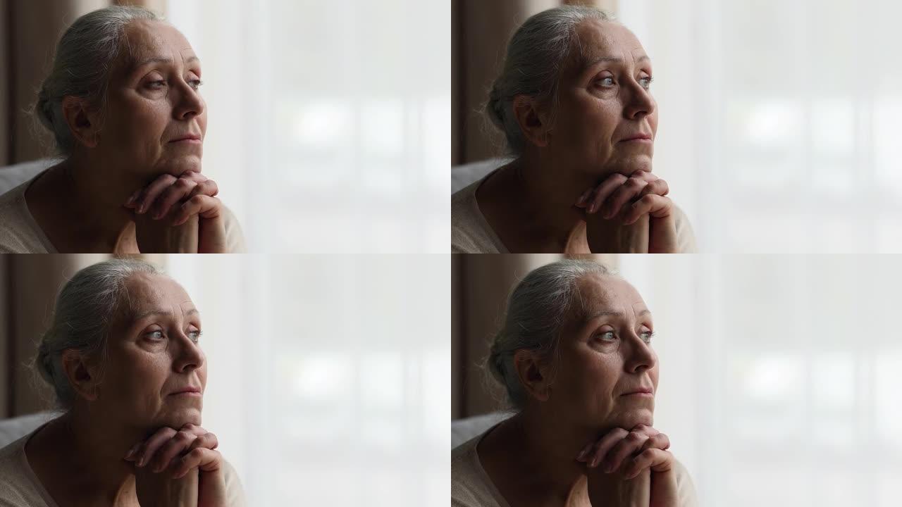 沉思的老年妇女看着距离经历感伤的渴望