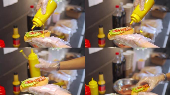 关闭个人视角中国快餐业工人在娱乐楼电影院电影院的特许摊位准备热狗三明治