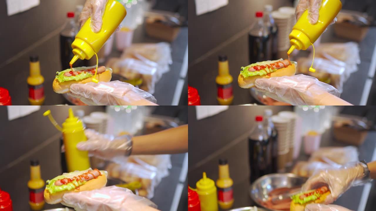 关闭个人视角中国快餐业工人在娱乐楼电影院电影院的特许摊位准备热狗三明治