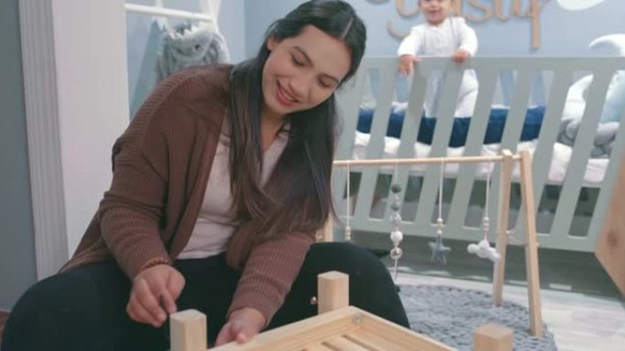 4k视频片段，一名年轻女子在家里的婴儿托儿所从事木制项目