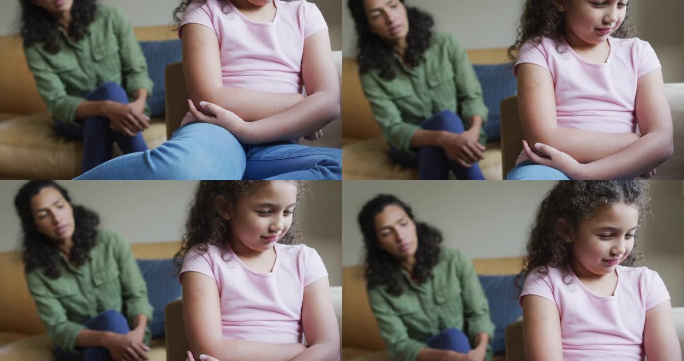 混血母亲在客厅的沙发上为悲伤的女儿提供建议