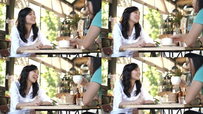 坐在街头咖啡馆的亚洲女性
