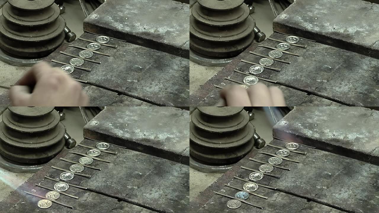工匠在阿根廷布宜诺斯艾利斯的车间制造Yerba Mate杯时，使用带有硬币的燃烧器烙铁。特写。