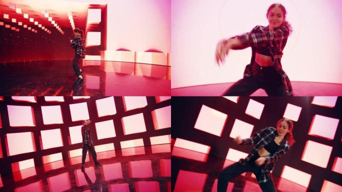 时尚的年轻专业女舞者在工作室环境中的虚拟制作过程中，在带有VFX动画的大Led墙壁屏幕前表演嘻哈舞蹈