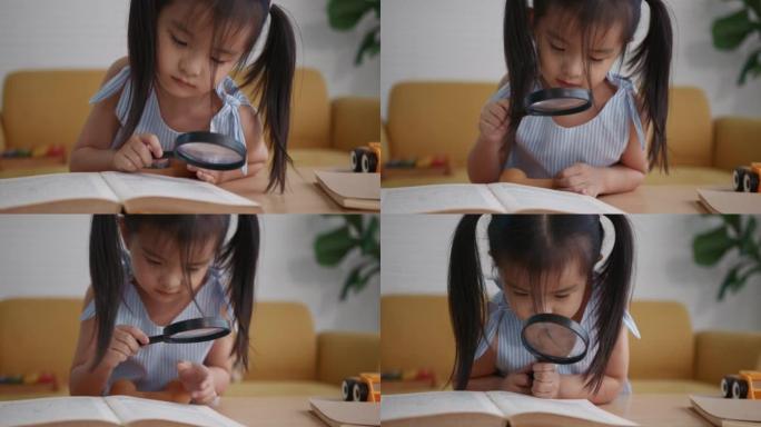 年轻的亚洲女孩读书放大镜在客厅