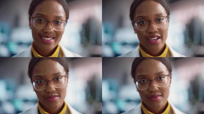 穿着实验室外套和眼镜微笑的年轻黑人女性专家的肖像特写。专业而成功的女性担任工程师，开发高科技项目