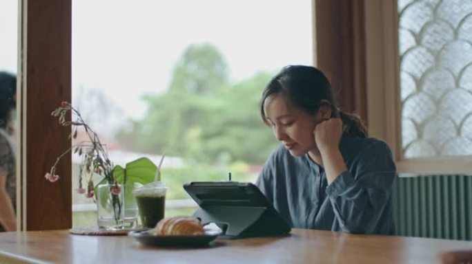 在咖啡馆使用数字平板电脑的女人