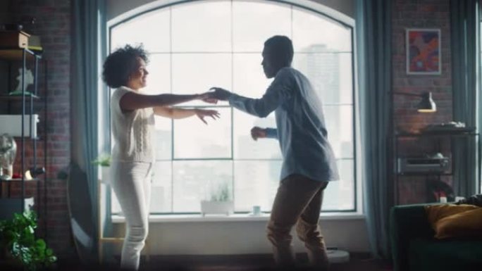 黑人与妻子跳舞，在客厅旋转她。非裔美国夫妇一起享受有趣的活跃周末。无忧无虑的人概念