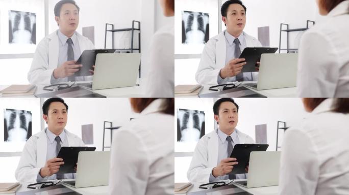 严重的亚洲男性医生使用剪贴板正在发表重大新闻谈话与女性患者坐在医院办公室的办公桌上讨论结果或症状。