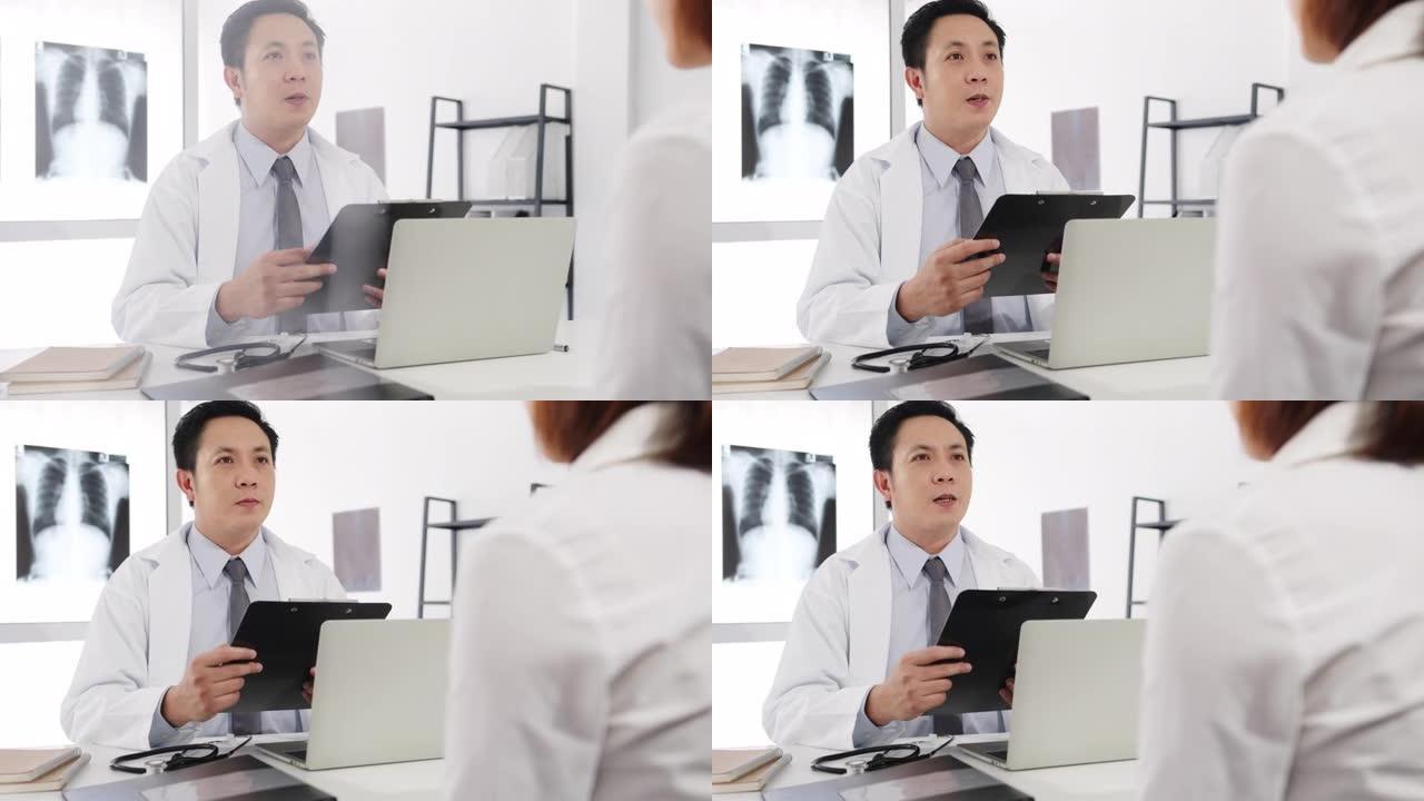 严重的亚洲男性医生使用剪贴板正在发表重大新闻谈话与女性患者坐在医院办公室的办公桌上讨论结果或症状。