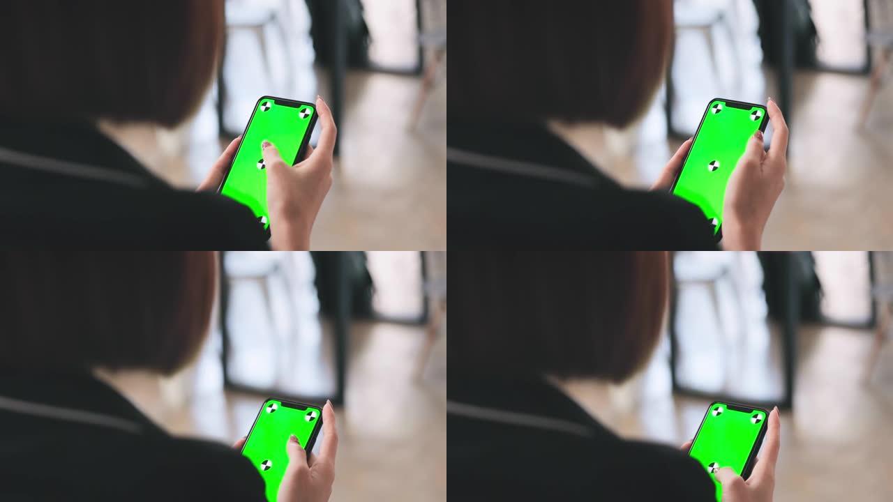 商业女性在工作中使用带有绿屏的智能手机