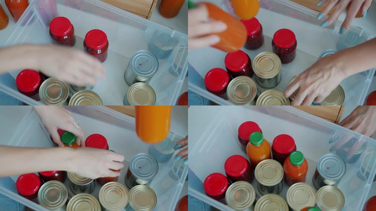 将罐头食品和果汁瓶放入容器中以供慈善基金捐赠的手的俯视图