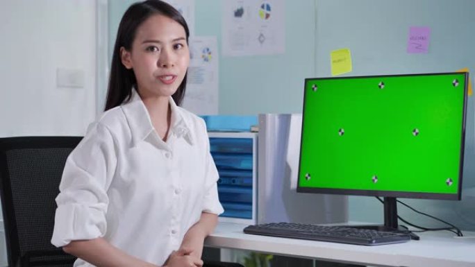 领导亚洲美丽的女商人在会议遥控器上在绿屏计算机上展示。绿屏