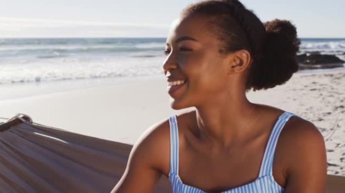 坐在海滩吊床上微笑的非洲裔美国妇女的特写镜头