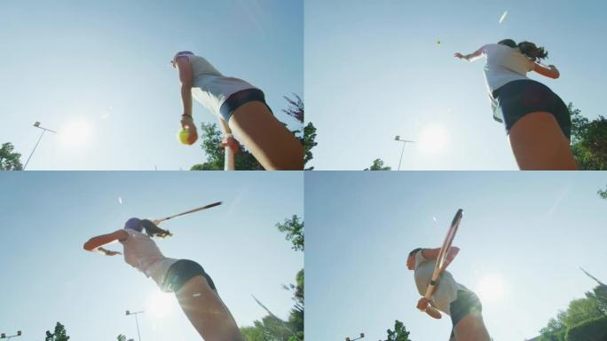 在阳光明媚的日子里，一名年轻的女子青少年网球运动员在球场上打友谊赛或训练锻炼游戏时正在发球。