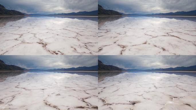 在死谷国家公园的Badwater盆地与水一起在盐壳地层的镜面中行走。美国加利福尼亚州