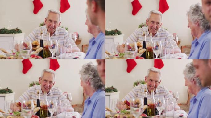 圣诞节期间，白人老人坐在餐桌上一起享用午餐时聊天