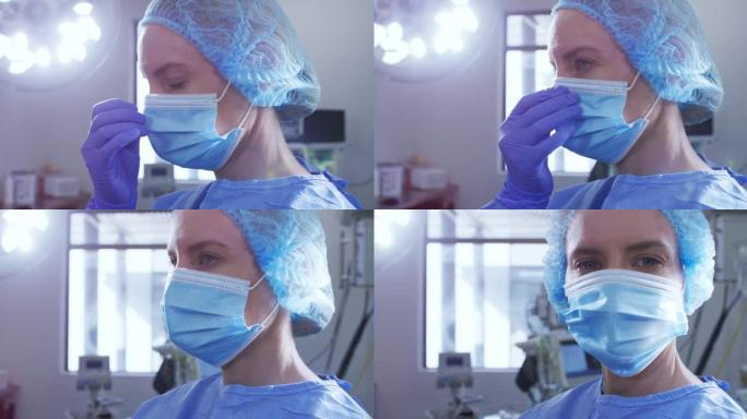 在医院里戴口罩，手术帽和防护服的白人女性外科医生