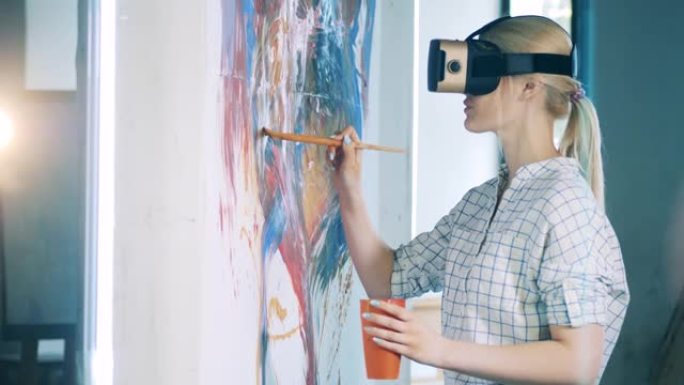 金发女人在绘画时使用VR眼镜和刷子