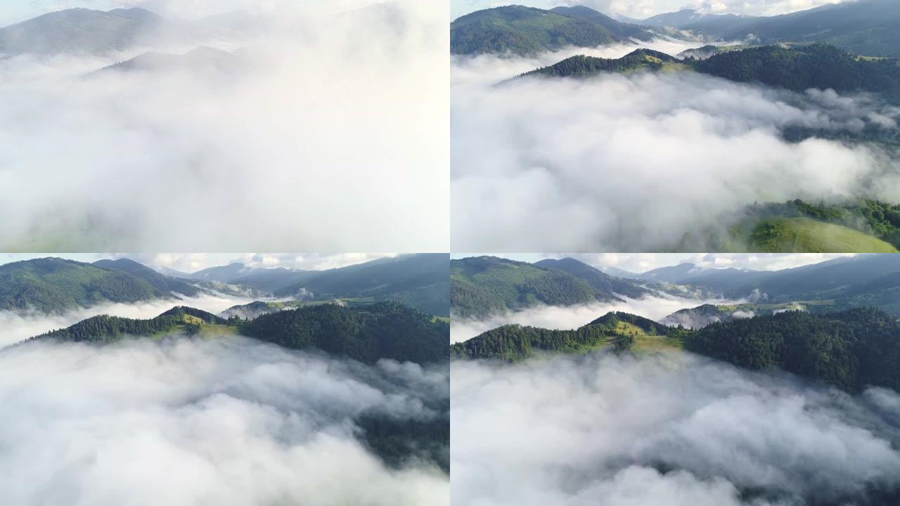在雾蒙蒙的绿色山丘上飞过云层。清晨被森林覆盖的壮丽山脉。生态旅游和乡村娱乐。空中射击，4K
