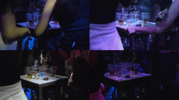 鸡尾酒杯在俱乐部的桌子上，一群人跳舞，慢动作