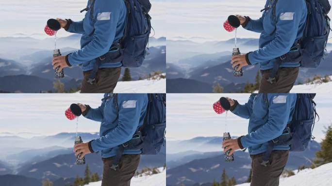 远足者将杯子中的水倒入雪山上的瓶子中