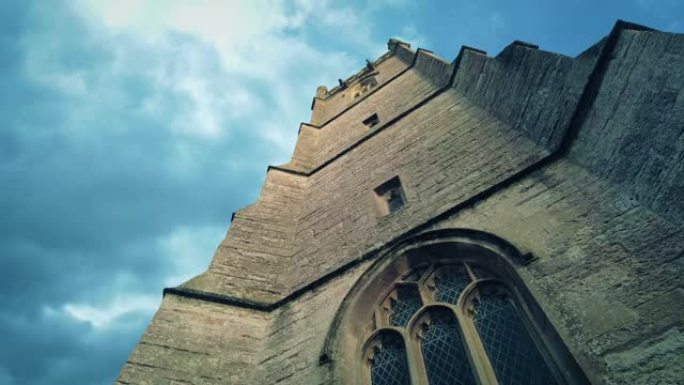 抬头看着中世纪的教堂塔楼，乌云密布