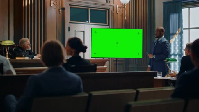 法庭开庭审理:魅力非凡的男性公设辩护人在绿色电视屏幕上向法官和陪审团展示证据的肖像。律师律师保护客户
